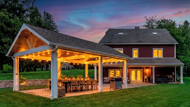 A house with a covered patio area, a garage, and a lawn. - Private Estate | Sleeps 35 | 9 Bed 9.5 Bath | 2 Homes | Theater | Pond | Sport Court | Hot Tub | Sauna (Ravenna)