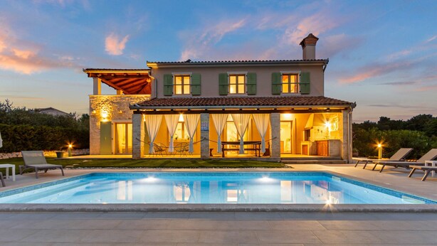 A two-story house with a swimming pool, outdoor seating, and a well-lit patio area. - Villa Stella Polaris with pool in Višnjan, Istria (Srebrnići)