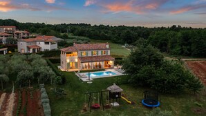 A large house with a swimming pool, surrounded by a well-maintained lawn and trees. - Villa Stella Polaris with pool in Višnjan, Istria (Srebrnići)