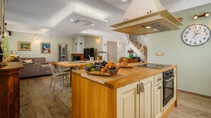 A spacious kitchen with a central island, a dining area, and a staircase leading to an upper level. - Villa Stella Polaris with pool in Višnjan, Istria (Srebrnići)