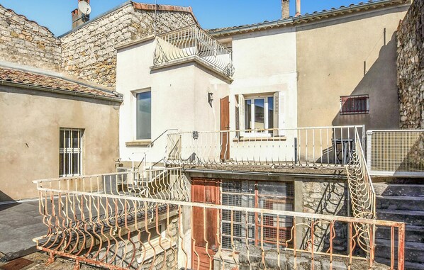 Traditional building with a balcony and staircase leading to the entrance.