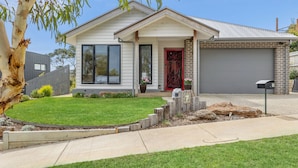 A single-story house with a front porch, a garage, and a well-maintained lawn.