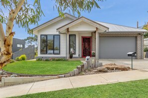 A single-story house with a front porch, a garage, and a well-maintained lawn.