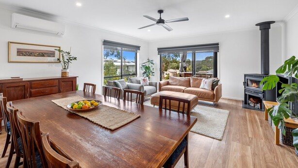 A spacious living area with a dining table, sofas, and a fireplace.