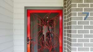 A door with a red frame and a decorative glass panel. - Porta Rossa (Anglesea)