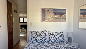 A bedroom with a bed, pillows, a bedside table, a lamp, and a painting on the wall. - Cozy attic penthouse in center of BCN. Sun, views, quiet... close to main spots. (Barcelona)