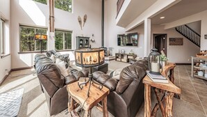 Un salon spacieux avec des canapés en cuir, une table basse en bois et une cheminée.