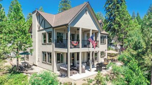 Une maison à deux étages avec un balcon, un espace extérieur aménagé pour s’asseoir et un drapeau.