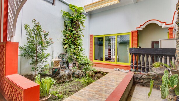 Un pati amb un camí empedrat, plantes en testos i un petit jardí de pedres.