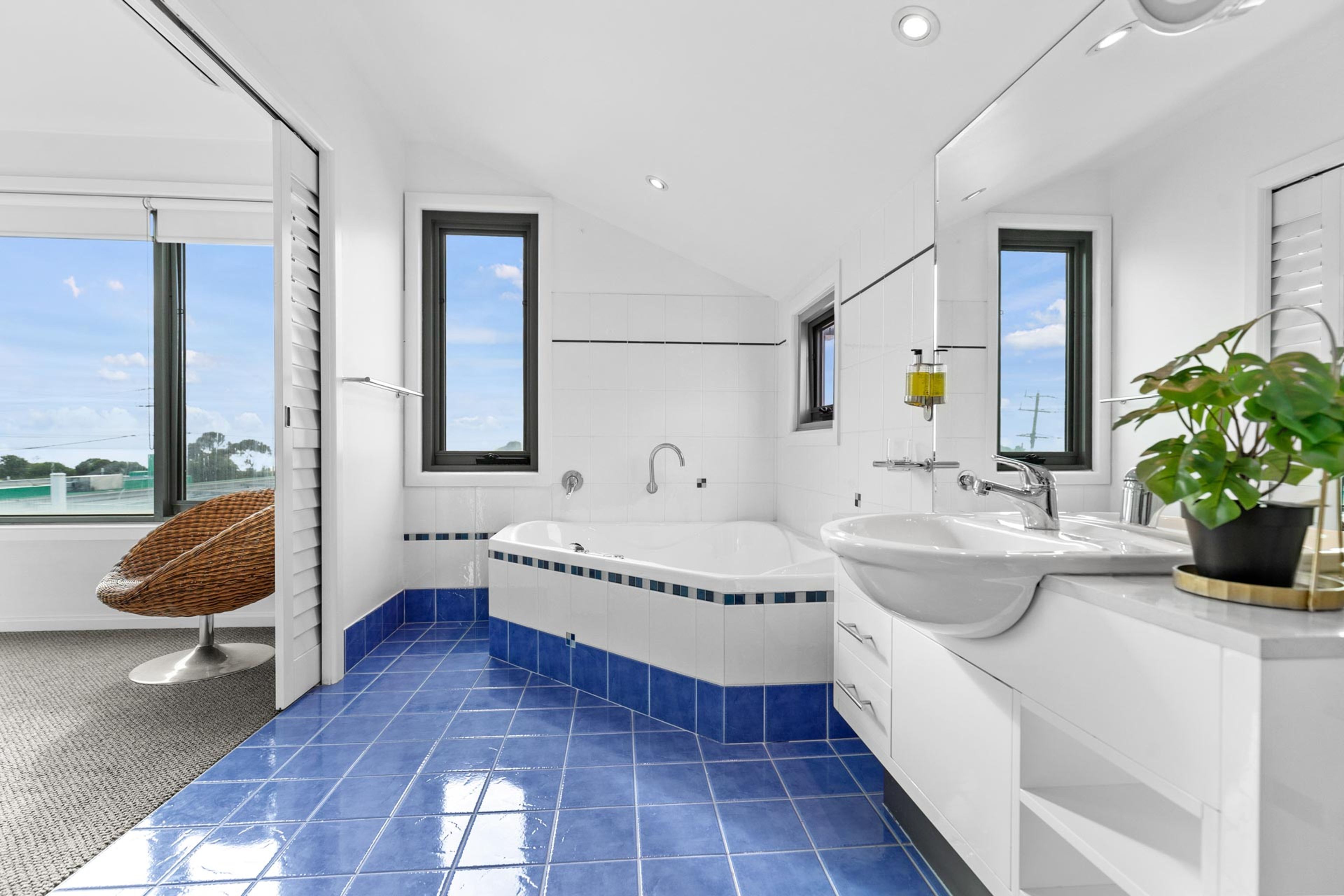 Une salle de bain moderne avec une baignoire, un lavabo et une fenêtre.