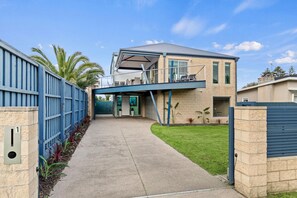 Een modern huis met twee verdiepingen, een overdekte veranda en een garage.