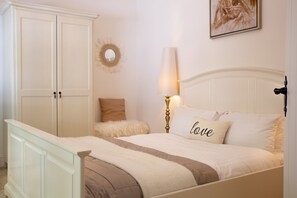 Una camera da letto con un letto, un comodino, una lampada, uno specchio e un armadio.
