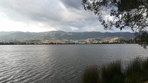 Un lago con un paisaje urbano al fondo, que incluye edificios y montañas.