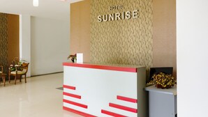 A hotel reception desk with a sign reading "HOTEL SUNRISE". - OYO 3343 Sunrise Hotel (Banjarbaru)