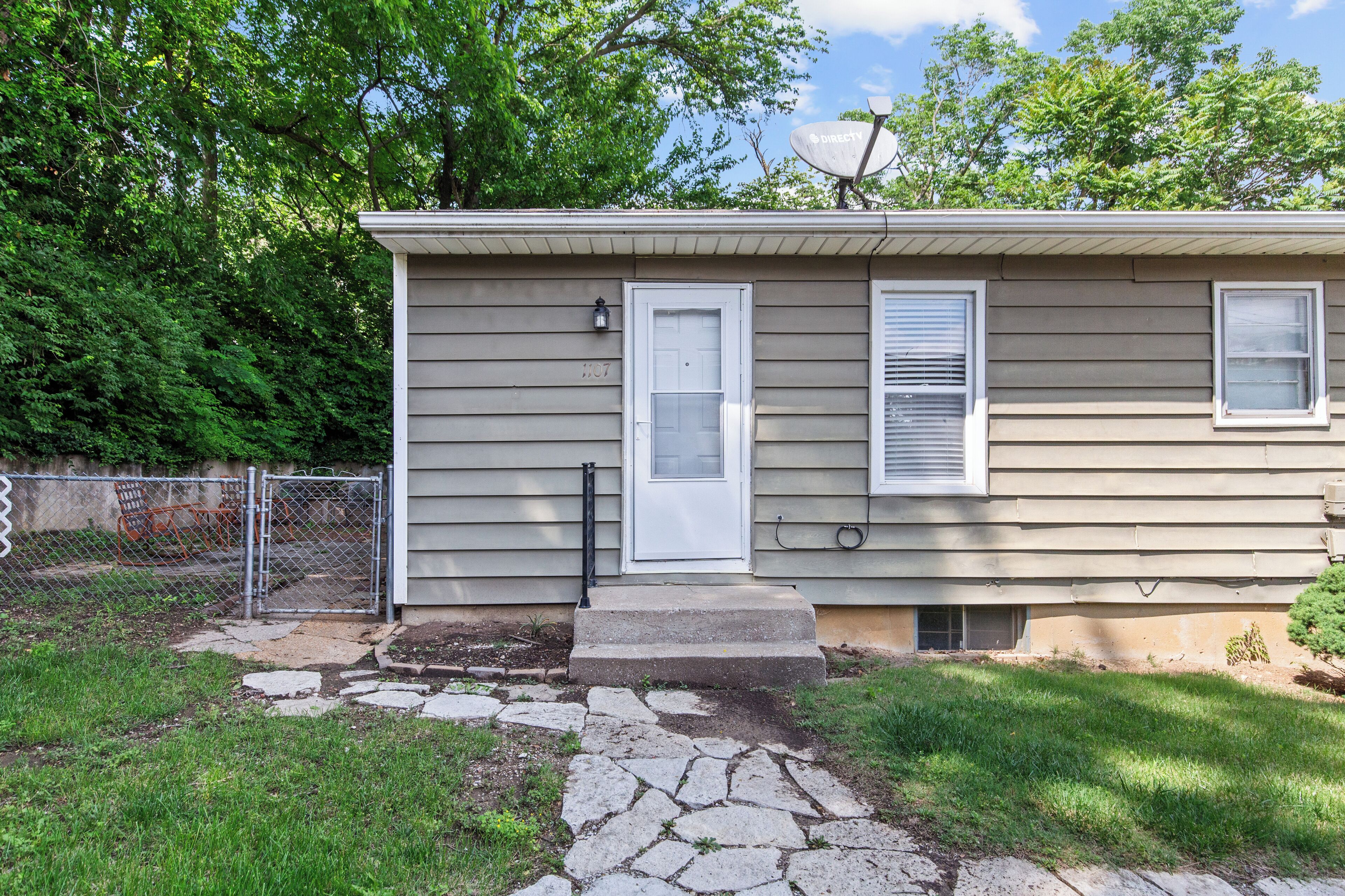 A single-story house with a front door, two windows, and a satellite dish.