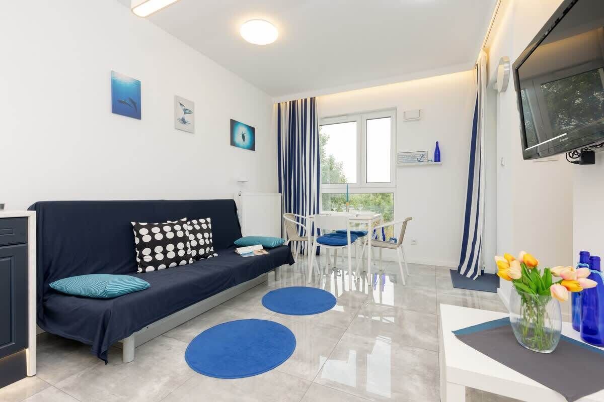 A bright living area with a navy sofa, blue accents, and coffee table.

