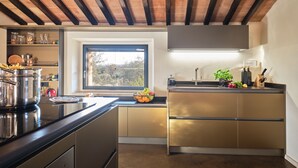Una cocina moderna con una isla grande, electrodomésticos integrados y un ventanal que proporciona luz natural.