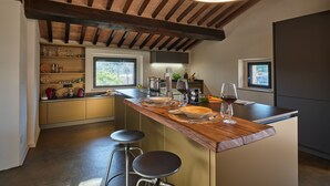 Una cocina moderna con techo de madera, estantes empotrados y una zona de bar con taburetes.
