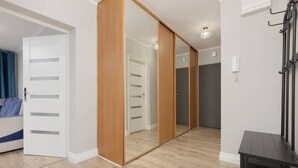 A room with a bed, a wardrobe, and a mirror. - Sunny Apartment | 2 Bedrooms, Balcony and Air Conditioning (Warszawa)