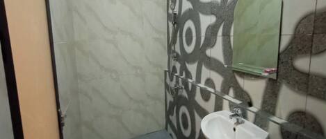 A bathroom with a white sink, a mirror, and patterned tiles on the walls.