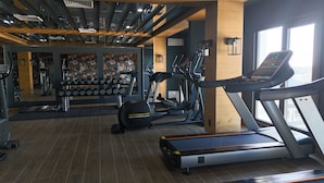 A gym with treadmills, elliptical machines, and weightlifting equipment. - Yogh Hospitality (Paramaribo)