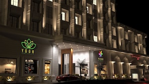 A hotel facade with illuminated signage for 'YOGH HOSPITALITY' and 'PASHA GLOBAL'. - Yogh Hospitality (Paramaribo)