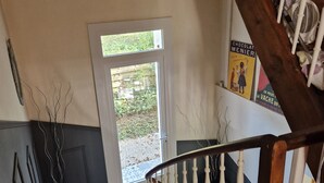 A staircase with white balusters and dark wooden steps leading to a door with a glass panel.