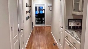 A hallway with wooden flooring, white walls, and a sign reading 'Lake House.' - Modern Lakefront Retreat - 3br 2ba (Sanford)