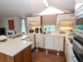 A compact kitchen with a central island, built-in appliances, and a window providing natural light.