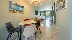 Habitación de hotel con comedor, cama y vista a la piscina.