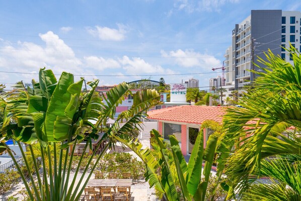 Un hotel con techo de tejas rojas, un letrero visible del 'City Inn Motel' y vistas de los edificios y palmeras circundantes.