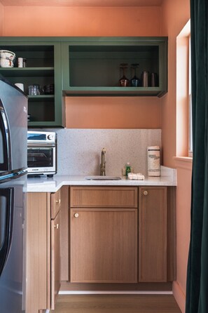 A compact kitchen with a built-in oven, a sink, and a countertop.