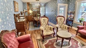 Un salon traditionnel, agrémenté de meubles décoratifs, comprenant un coin repas et offrant une vue sur l’extérieur.