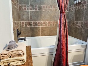 Bañera, secador de pelo, toallas y champú