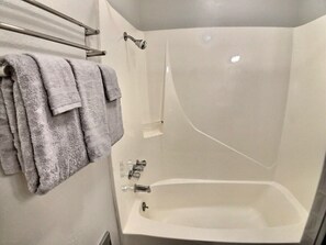 Een bad, een haardroger, handdoeken, shampoo