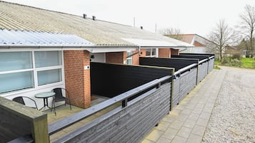 Række af lave bygninger med murstensvægge og metal tage.