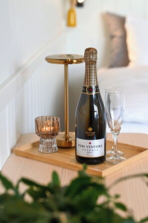A bottle of Pere Ventura Reserva Brut wine, a candle, and a glass on a wooden tray. - Rold Gl. Kro (Arden)