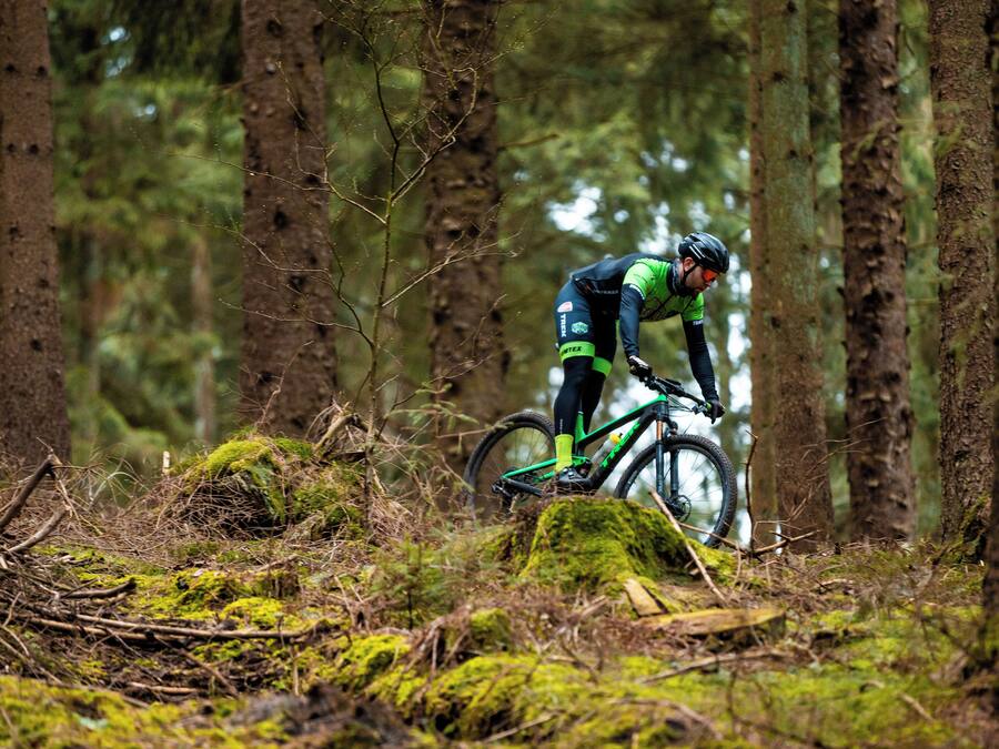 Un ciclista de montaña recorre un sendero en el bosque.