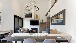 Una sala de estar moderna con chimenea, una mesa de comedor y asientos cómodos.