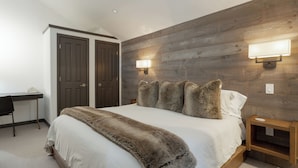 Un dormitorio con una cama grande, dos armarios, un escritorio y dos luces empotradas.