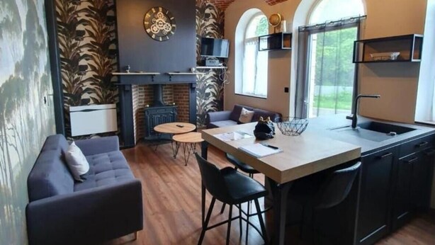 Una cocina moderna con techo de ladrillo, un área de comedor con sofá y un ventanal grande.