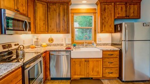 A kitchen with wooden cabinets, stainless steel appliances, a dishwasher, and a refrigerator.