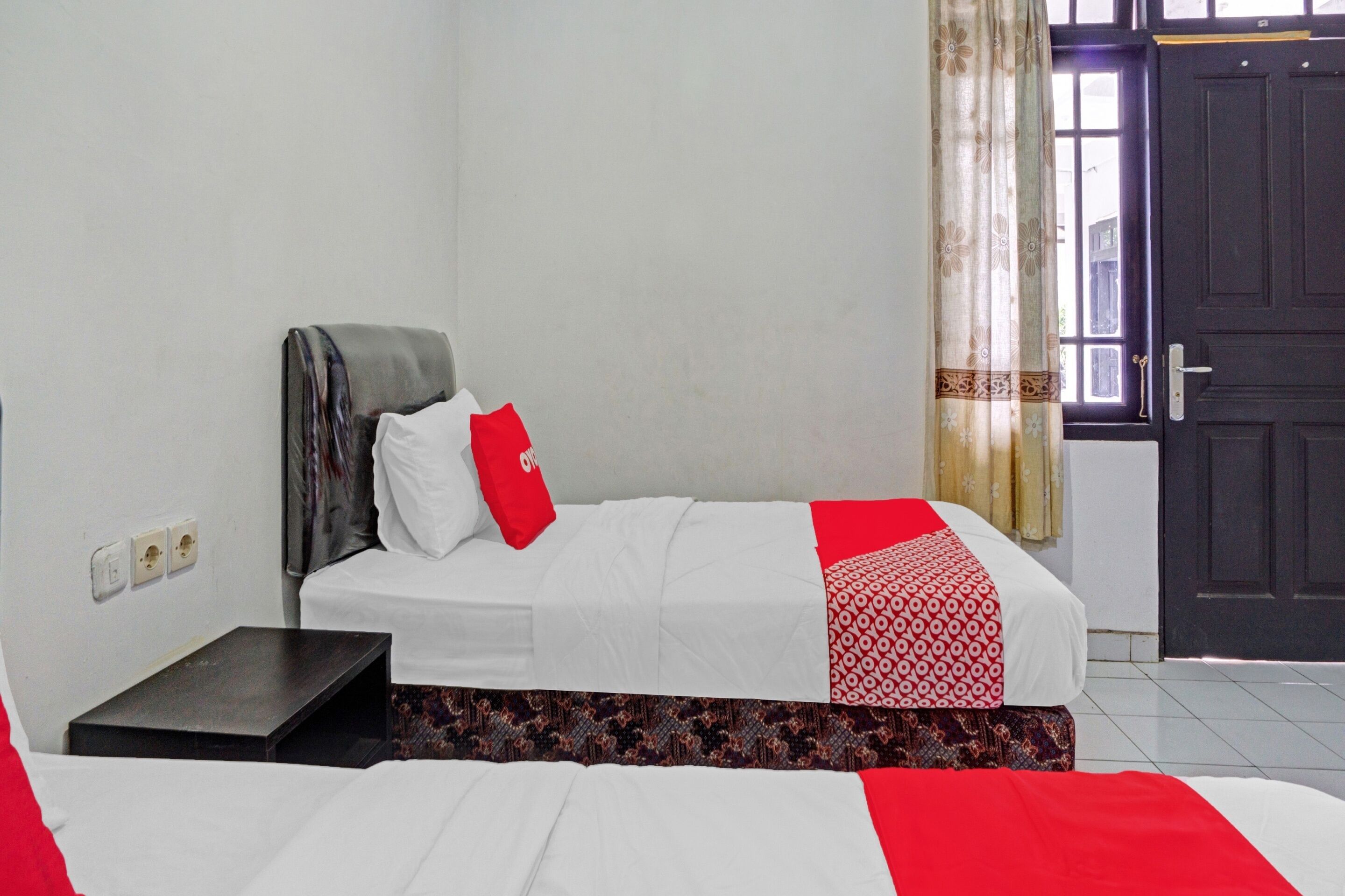 Une chambre d’hôtel avec un lit, une petite table, une armoire et une porte.