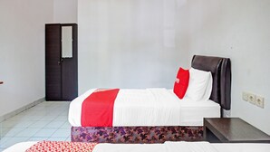 Una camera d'albergo con un letto, un comodino e un armadio.