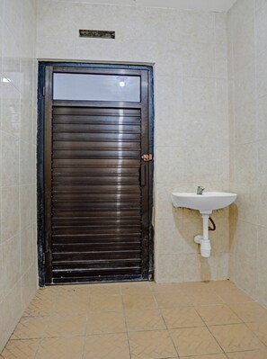 bathroom with pedestal sink and tile flooring.