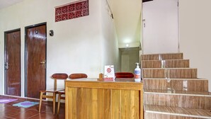 Un comptoir d’accueil avec une pancarte, deux portes en bois portant les numéros 7 et 8, et un escalier muni d’une main courante.