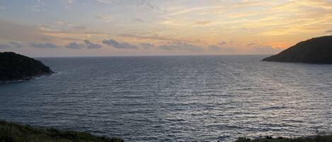 A coastal landscape with a clear view of the sea and a hilly terrain.