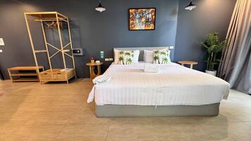 A modern hotel room with a large bed, a wooden ladder, a small table, and a wall-mounted artwork.