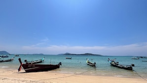 A beach with several boats anchored in the water. - Phuket Muay Thai Hotel Rawai Beach (Rawai)