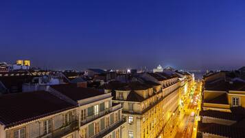 Vista nocturna de un paisaje urbano con edificios a lo largo de una calle iluminada.
